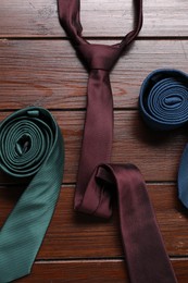 Different neckties on wooden table, flat lay