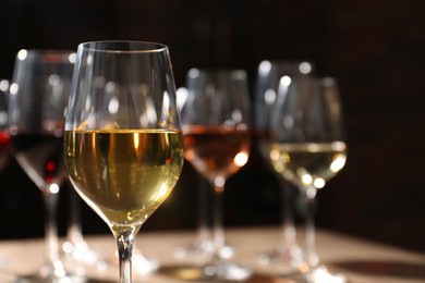 Photo of Tasty white wine in glass against blurred background, space for text