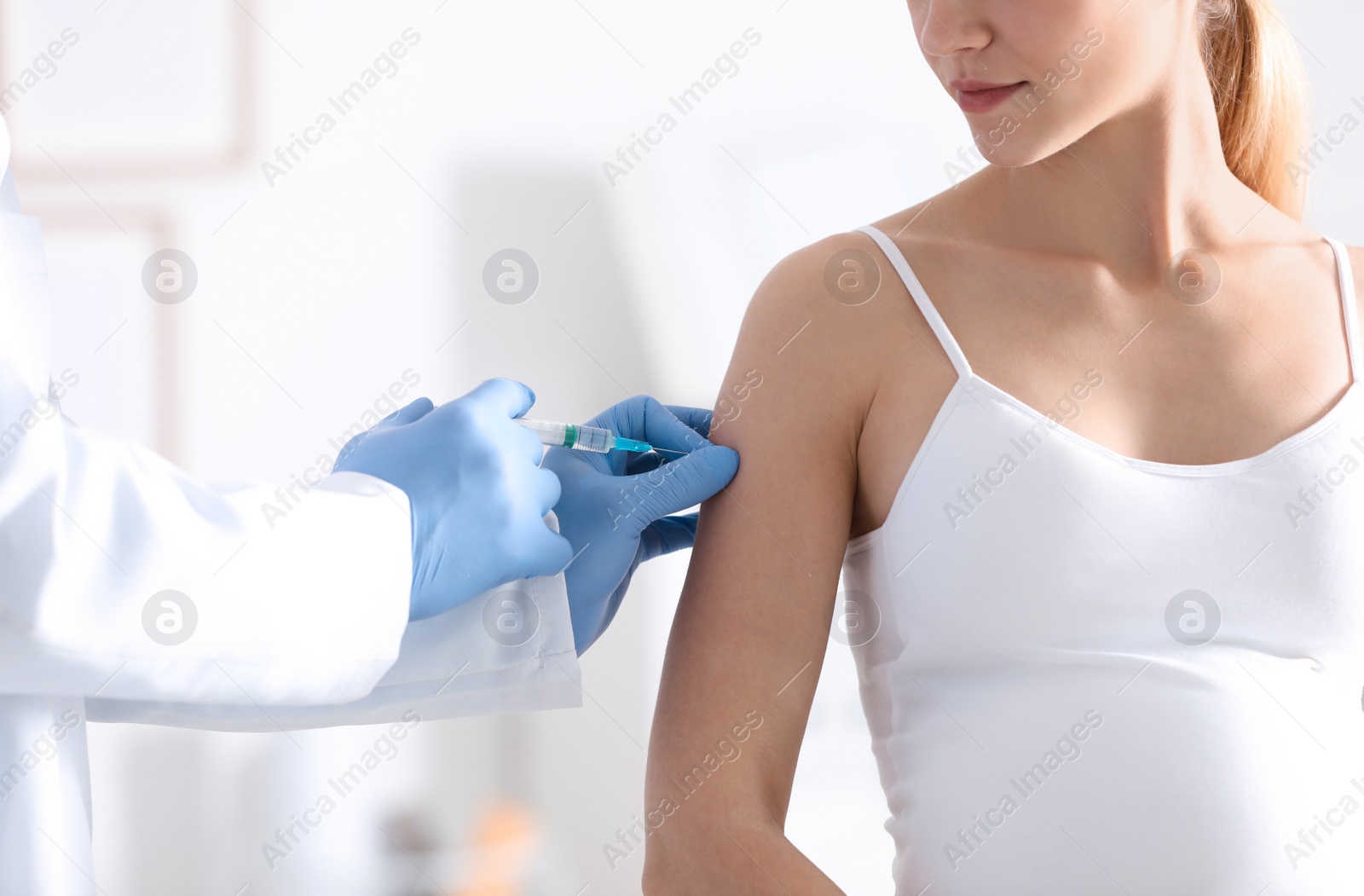 Photo of Doctor giving injection to pregnant woman in hospital, closeup. Vaccination concept