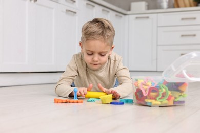 Cute little boy playing on warm floor in kitchen. Heating system