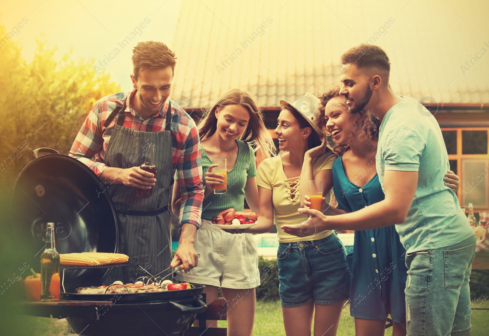 Image of Group of friends with drinks near barbecue grill outdoors on sunny day