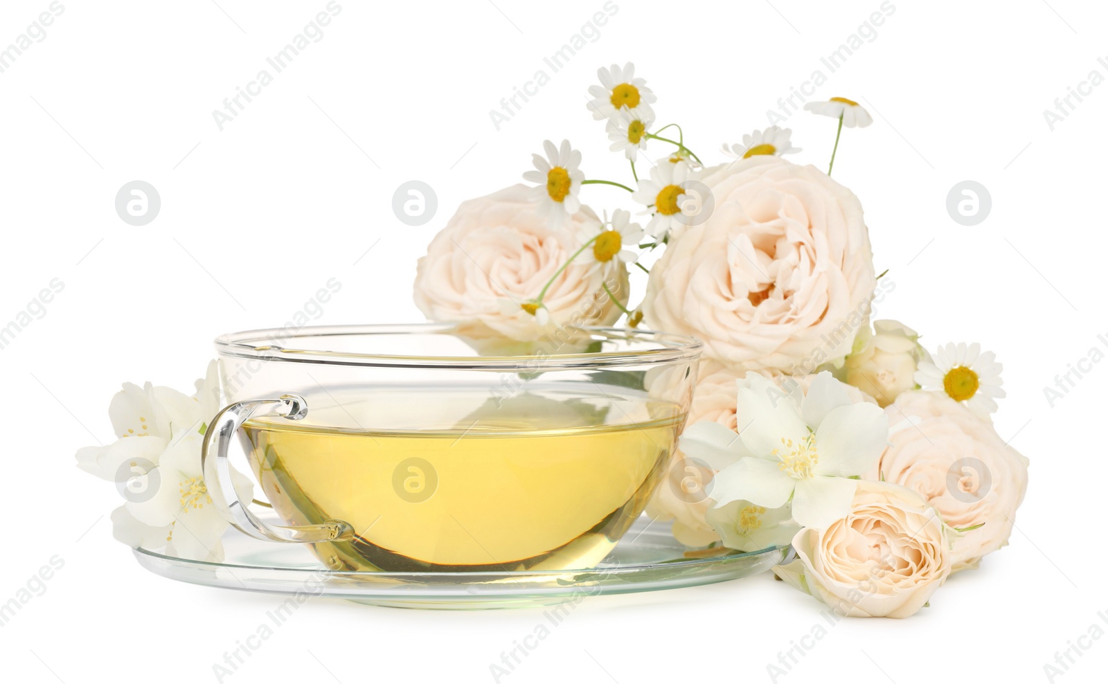 Photo of Aromatic herbal tea in glass cup and flowers isolated on white