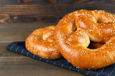 Photo of Tasty freshly baked pretzels on wooden table, closeup view