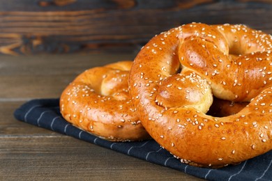 Tasty freshly baked pretzels on wooden table, closeup view