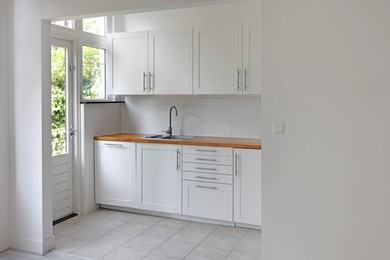 Interior of modern kitchen with stylish white furniture