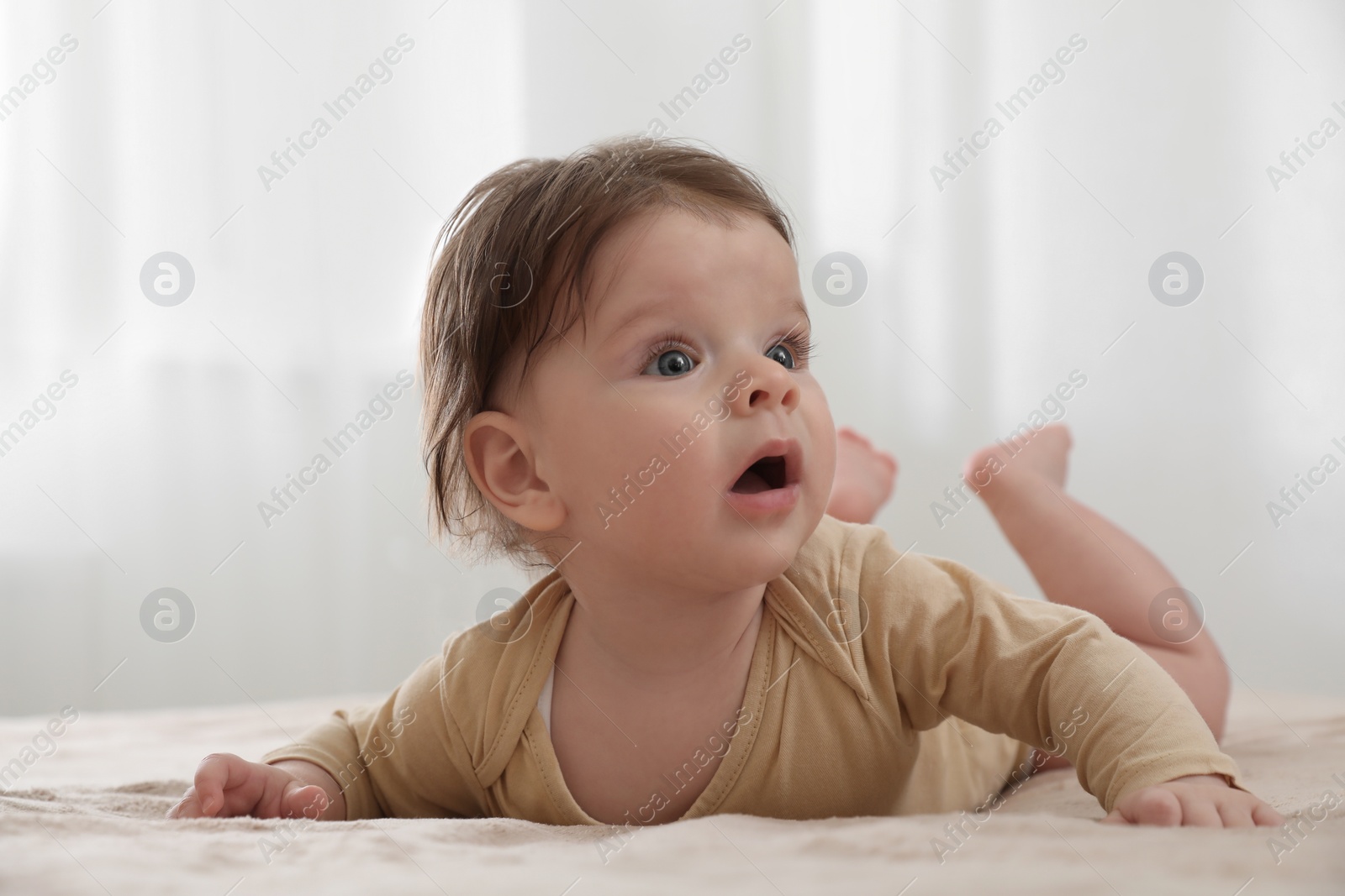 Photo of Portrait of cute little baby on bed indoors