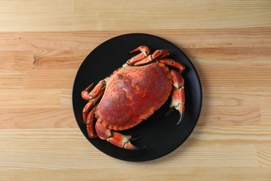 Photo of Delicious boiled crab on wooden table, top view