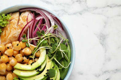 Photo of Delicious avocado salad with chickpea on white marble table, top view. Space for text