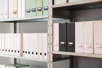 Photo of Folders with documents on shelves in archive
