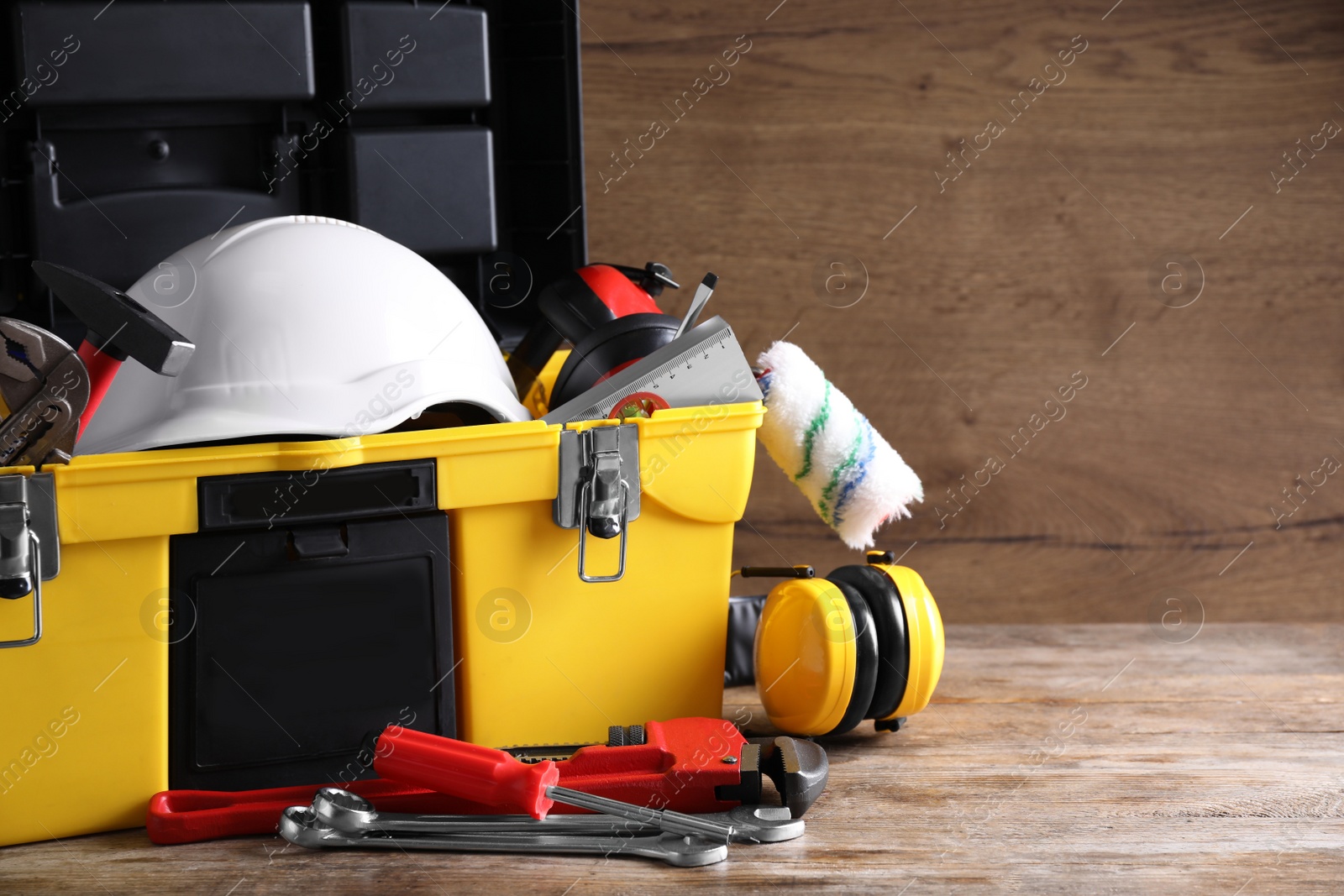 Photo of Plastic box with construction tools on wooden table. Space for text