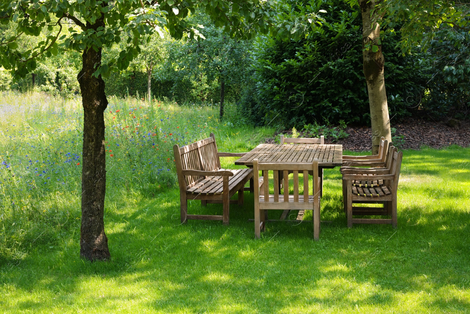 Photo of Empty wooden table with bench and chairs in garden