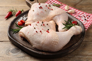 Photo of Raw chicken leg quarters and ingredients on wooden table