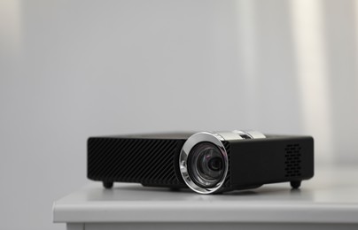 Photo of Modern video projector on white table indoors