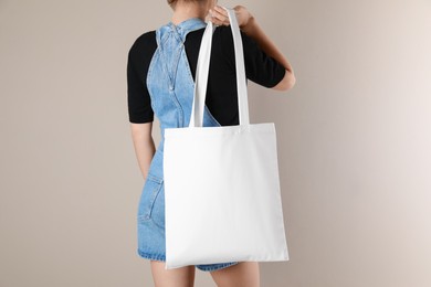 Photo of Woman with textile bag on beige background, closeup. Space for design