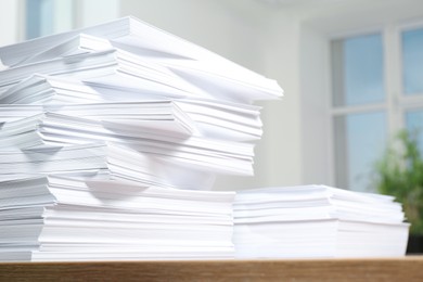 Stacks of paper sheets on wooden table indoors, closeup