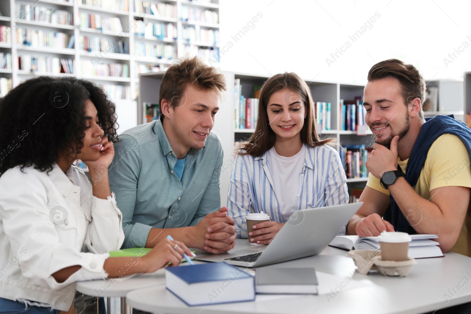 Photo of Group of young people studying at table in library