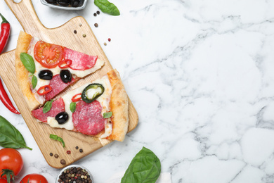 Flat lay composition with pieces of delicious pizza Diablo and ingredients on white marble background. Space for text