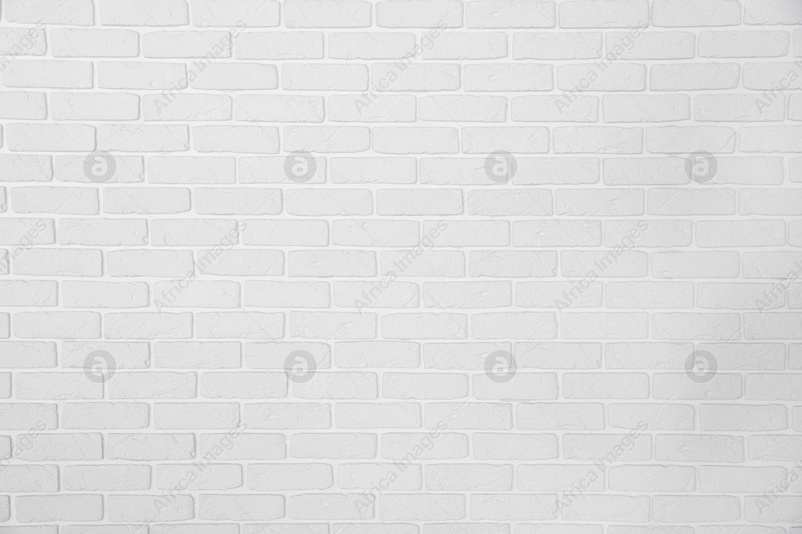 Photo of Decorative white bricks with tile leveling system on wall