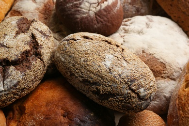 Photo of Different kinds of delicious bread as background, closeup