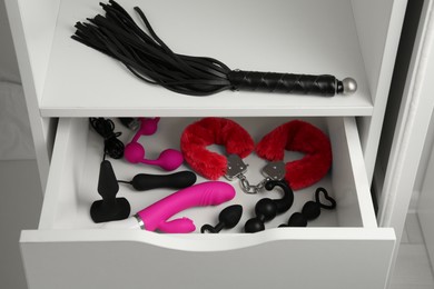 Photo of Nightstand with many different sex toys indoors, closeup