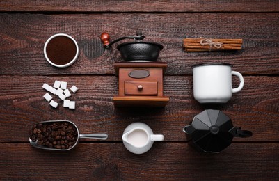 Flat lay composition with vintage manual grinder and geyser coffee maker on wooden background