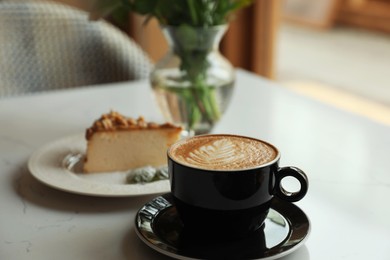 Photo of Cup of fresh coffee and dessert on table indoors