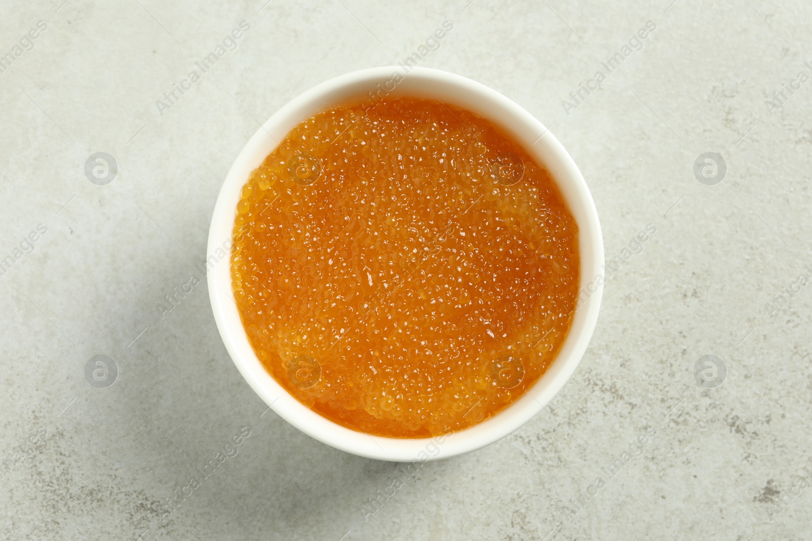 Photo of Fresh pike caviar in bowl on light grey table, top view