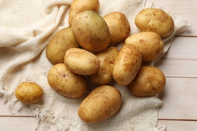 Photo of Raw fresh potatoes on light wooden table, top view