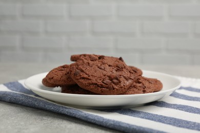 Photo of Delicious chocolate chip cookies on light grey table, closeup. Space for text