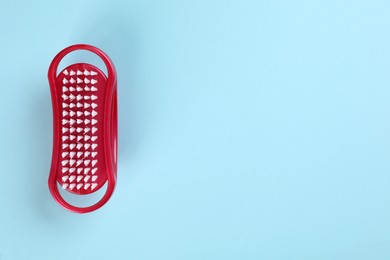 Pedicure foot brush on light blue background, top view. Space for text