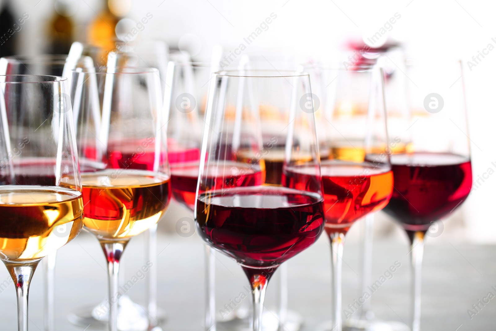 Photo of Glasses with different wines on blurred background, closeup