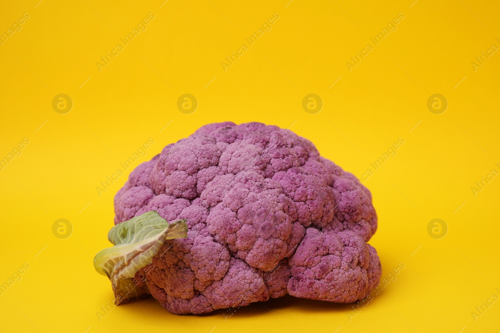 Photo of Fresh raw purple cauliflower on yellow background. Healthy food