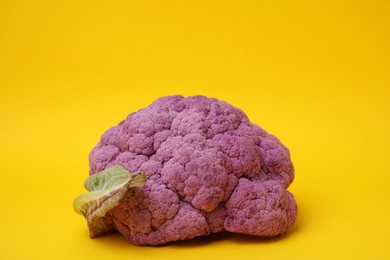 Photo of Fresh raw purple cauliflower on yellow background. Healthy food