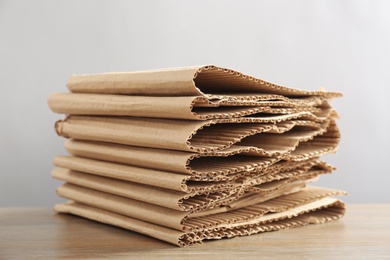 Stack of cardboard on table against light background, closeup. Recycling concept