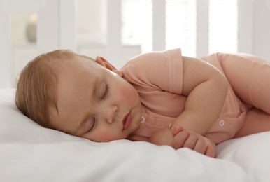Photo of Cute little baby sleeping in soft crib, closeup
