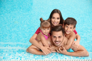 Happy family resting in swimming pool with refreshing water