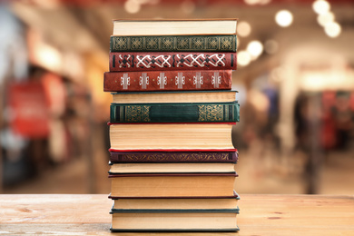 Collection of different books on wooden table against blurred background