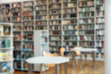 Photo of Blurred view of bookshelves and tables in library