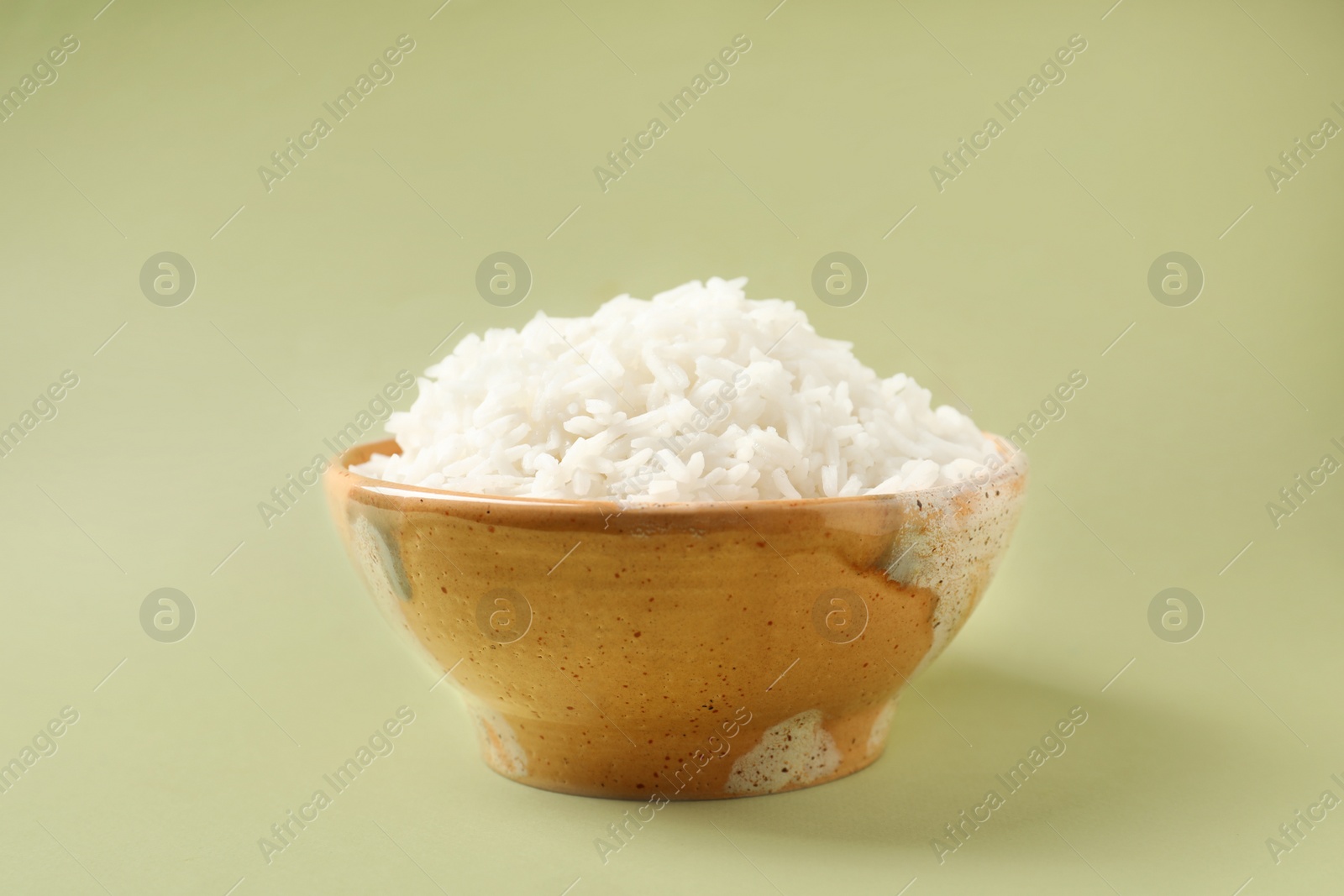 Photo of Bowl of tasty cooked rice on color background