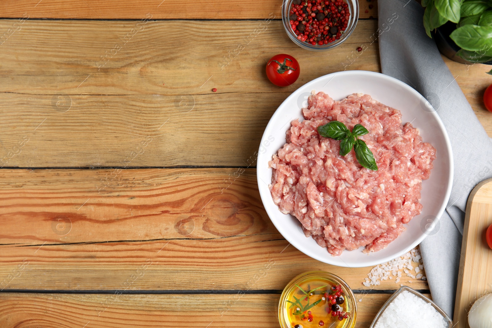 Photo of Raw chicken minced meat and ingredients on wooden table, flat lay. Space for text