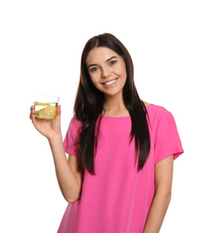 Beautiful young woman with tasty lemon water on white background