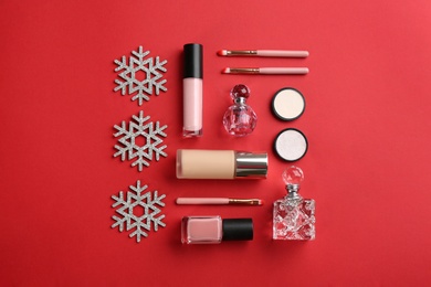 Photo of Flat lay composition with decorative cosmetic products on red background. Winter care