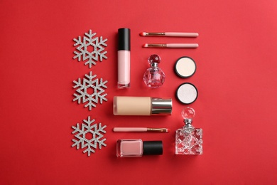 Flat lay composition with decorative cosmetic products on red background. Winter care