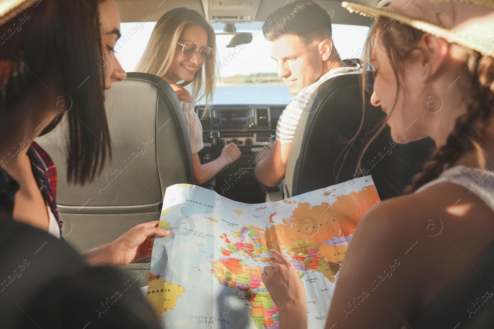 Photo of Happy friends with map in car on road trip