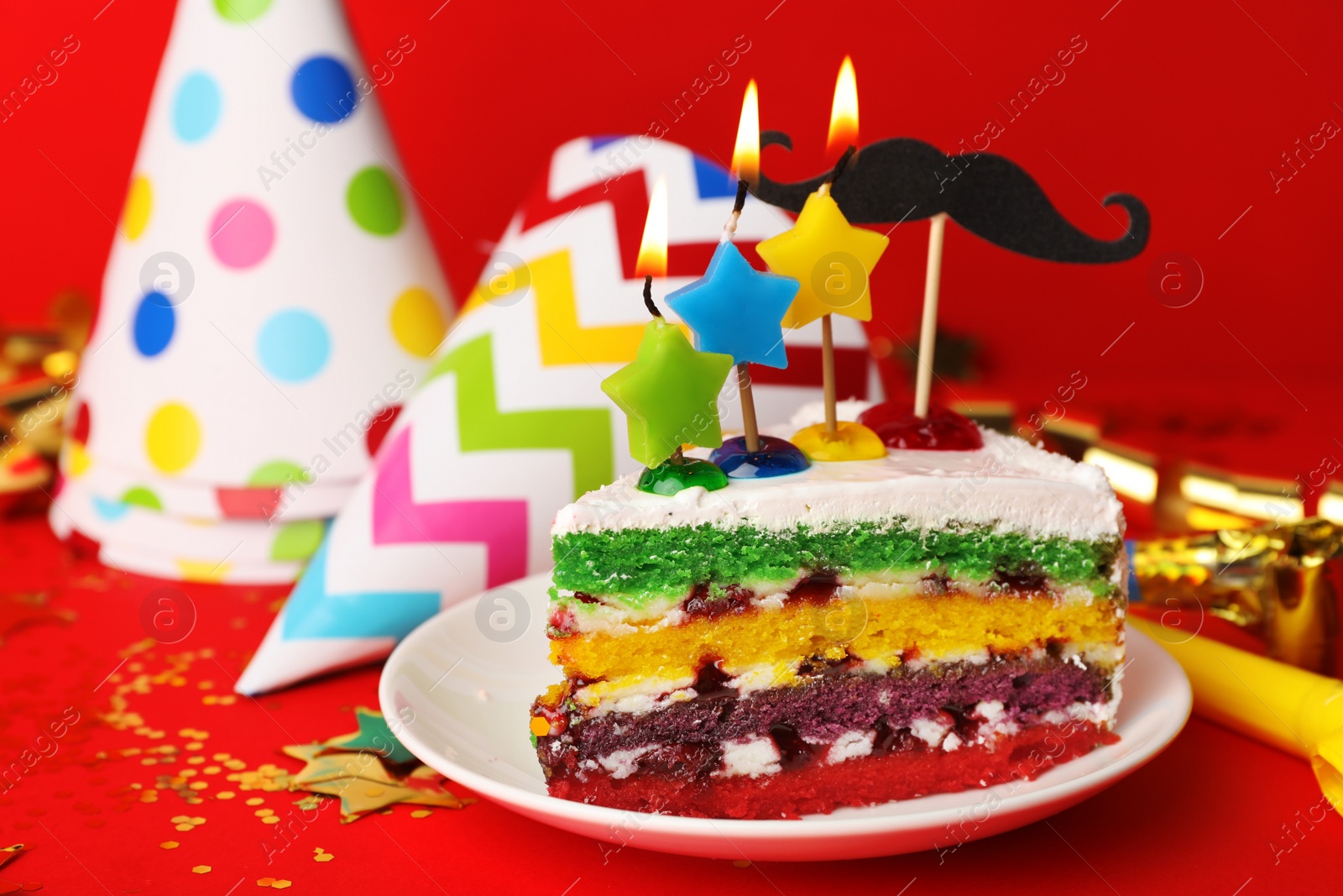 Photo of Piece of birthday cake with candles on red background