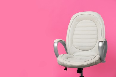 Comfortable office chair on pink background, space for text