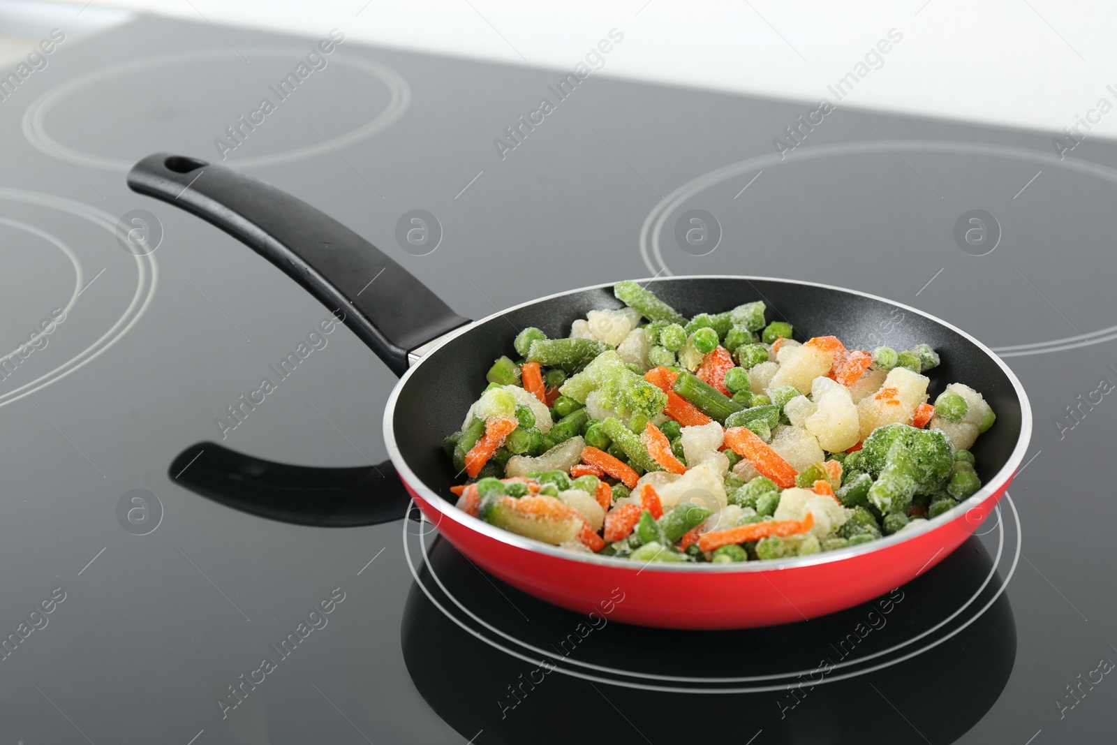 Photo of Cooking tasty frozen vegetable mix on induction stove