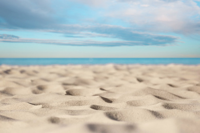 Sandy beach near sea under blue sky with clouds