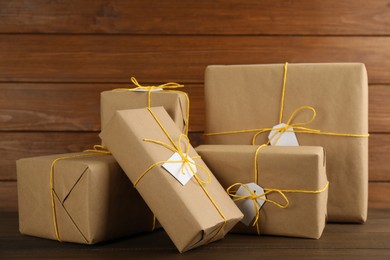 Parcels wrapped in kraft paper with tags on wooden table