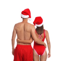 Photo of Lovely couple with Santa hats together on white background, back view. Christmas vacation
